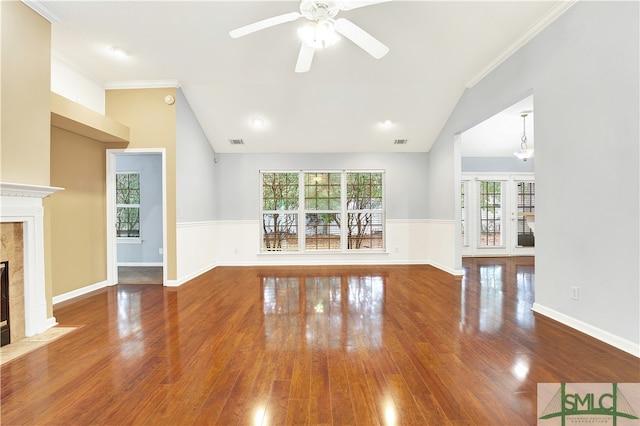 unfurnished living room with lofted ceiling, wood-type flooring, a tile fireplace, and crown molding