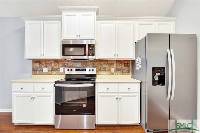 kitchen featuring appliances with stainless steel finishes, decorative backsplash, white cabinets, and light hardwood / wood-style floors