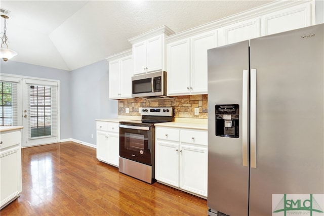 kitchen with white cabinetry, light hardwood / wood-style floors, stainless steel appliances, lofted ceiling, and pendant lighting