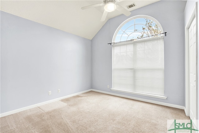 empty room featuring lofted ceiling, light carpet, and ceiling fan