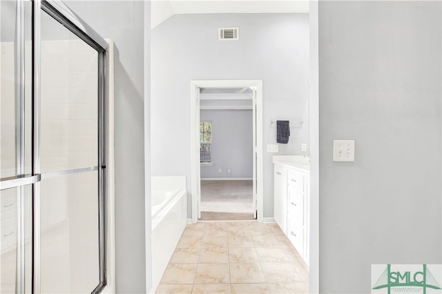 bathroom with vanity, vaulted ceiling, separate shower and tub, and tile patterned floors