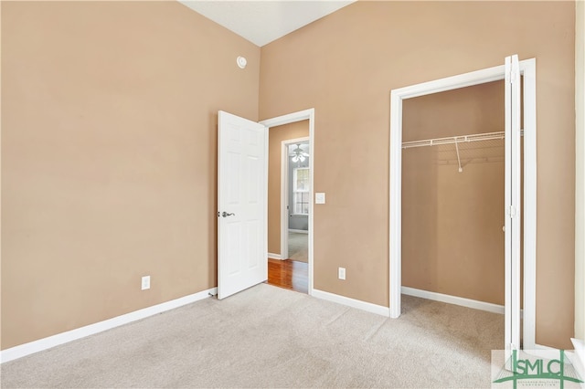 unfurnished bedroom with light carpet and a closet