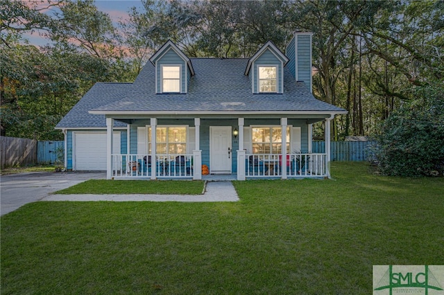 cape cod-style house featuring a yard and covered porch