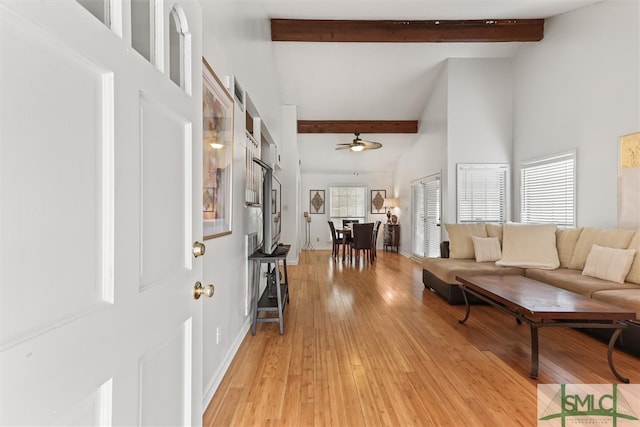 foyer entrance with ceiling fan, beam ceiling, light wood-type flooring, and high vaulted ceiling