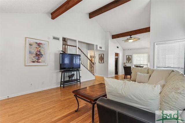 living room with hardwood / wood-style floors, ceiling fan, beamed ceiling, and high vaulted ceiling