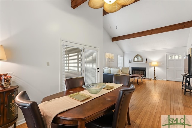 dining room featuring ceiling fan, beam ceiling, high vaulted ceiling, and light hardwood / wood-style flooring