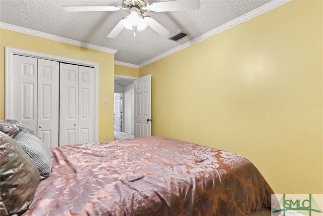 bedroom featuring ceiling fan, a closet, a textured ceiling, and ornamental molding