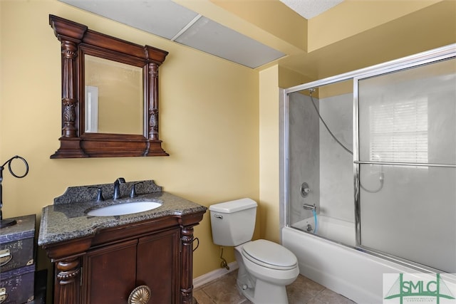 full bathroom featuring tile patterned flooring, vanity, toilet, and bath / shower combo with glass door