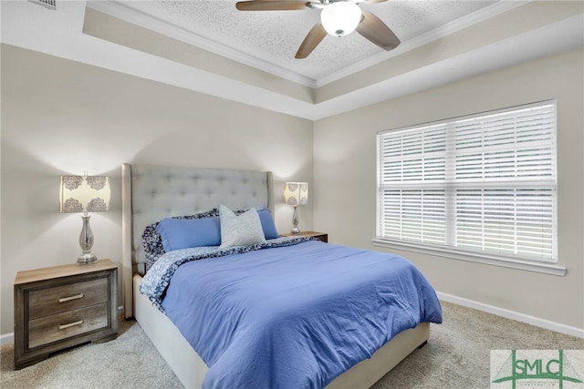 bedroom featuring a textured ceiling, a tray ceiling, ceiling fan, crown molding, and light colored carpet