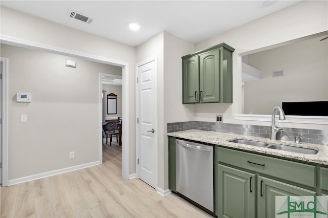 kitchen featuring sink, dishwasher, light wood-type flooring, backsplash, and green cabinets