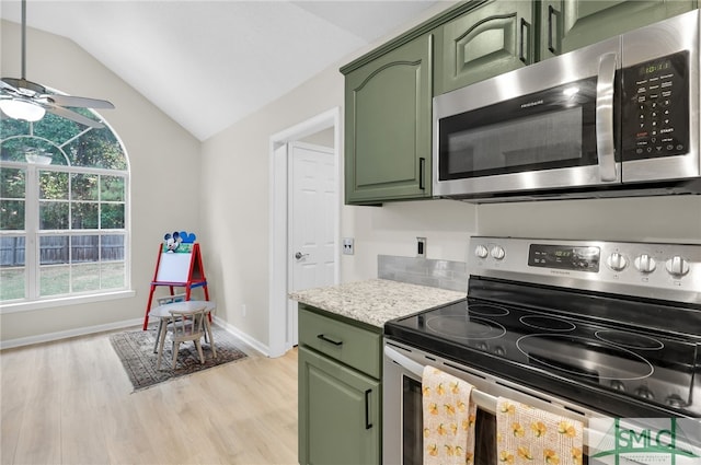 kitchen with lofted ceiling, green cabinets, stainless steel appliances, and a wealth of natural light