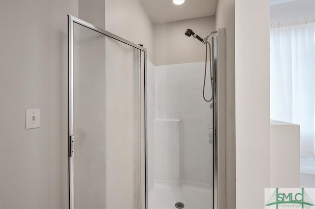 bathroom featuring a shower with shower door