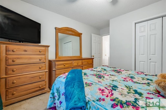 carpeted bedroom featuring a closet and a textured ceiling