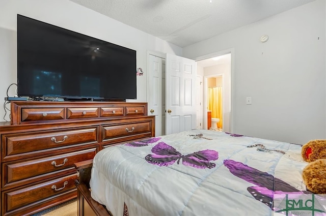 bedroom with a textured ceiling and ensuite bath