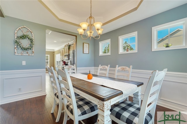 dining space featuring a tray ceiling, a wealth of natural light, a chandelier, and dark hardwood / wood-style floors