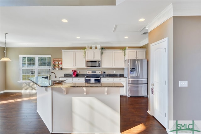 kitchen featuring dark wood-type flooring, appliances with stainless steel finishes, white cabinetry, and dark stone countertops