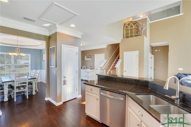 kitchen featuring dishwasher, dark wood-type flooring, dark stone counters, sink, and decorative light fixtures