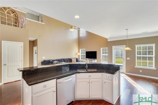 kitchen featuring stainless steel dishwasher, sink, white cabinets, and an island with sink