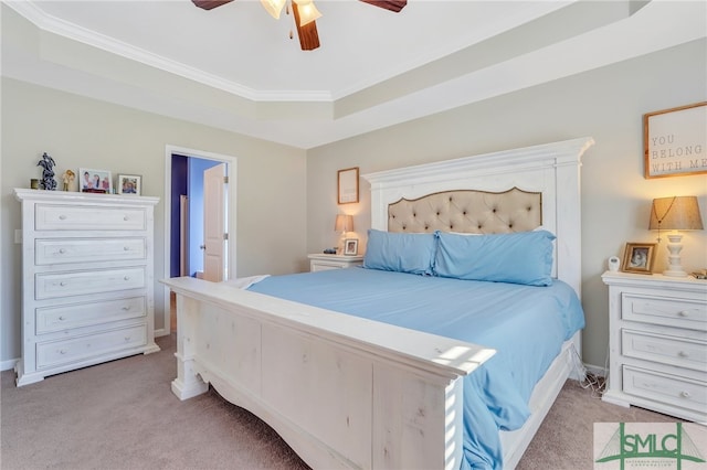 carpeted bedroom featuring ceiling fan, a raised ceiling, and crown molding