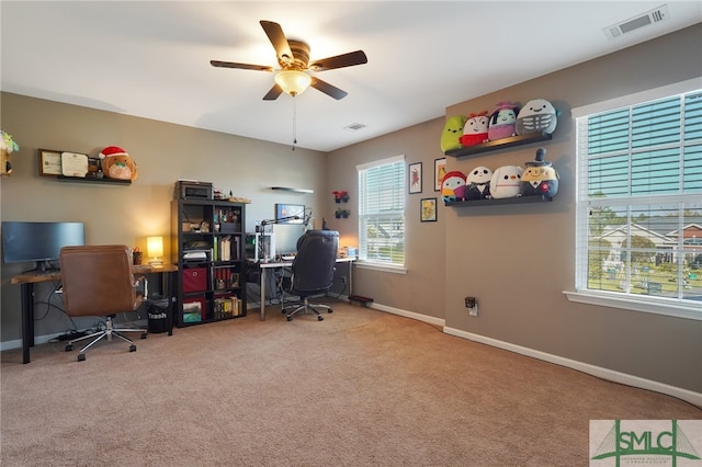 carpeted home office featuring ceiling fan