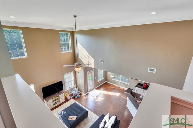 living room featuring ceiling fan, ornamental molding, plenty of natural light, and hardwood / wood-style floors