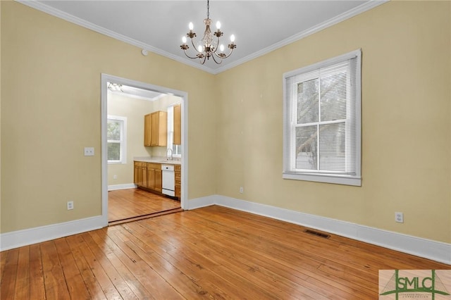 124 Brady St, Savannah, GA 31401 - spare room featuring a chandelier, light wood-style flooring, crown molding, baseboards, and a sink