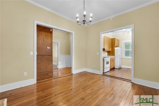 interior space with light wood-type flooring, a chandelier, and crown molding