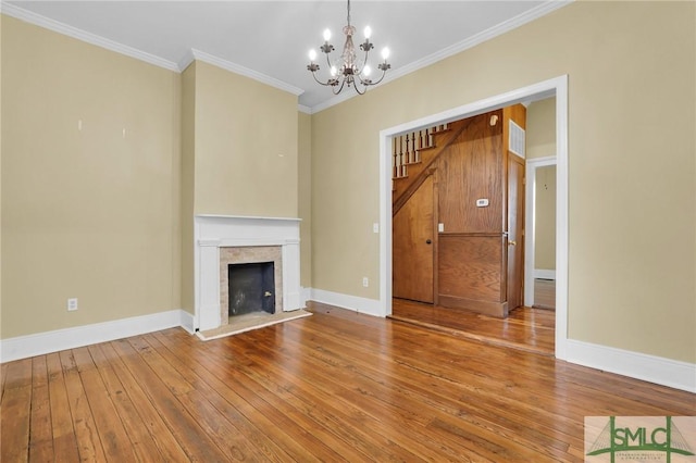 124 Brady St, Savannah, GA 31401 - unfurnished living room with a chandelier, hardwood / wood-style flooring, crown molding, stairway, and baseboards