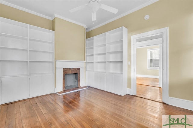 unfurnished living room featuring hardwood / wood-style floors, ceiling fan, and crown molding