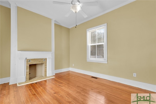 unfurnished living room with hardwood / wood-style floors, a fireplace, ceiling fan, and crown molding