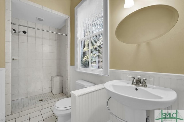 124 Brady St, Savannah, GA 31401 - full bathroom featuring toilet, tiled shower, a wainscoted wall, tile patterned flooring, and a sink