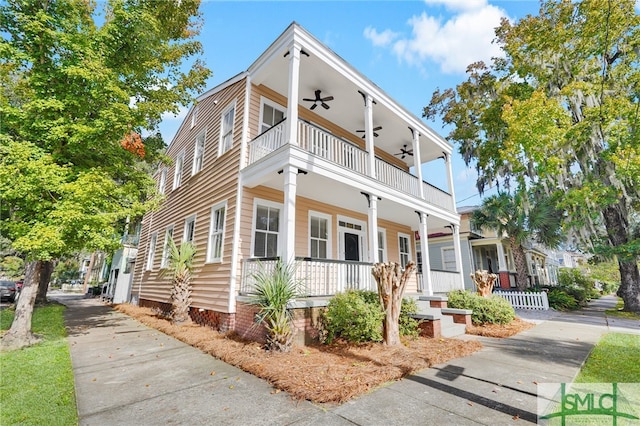 view of front facade with covered porch, ceiling fan, and a balcony