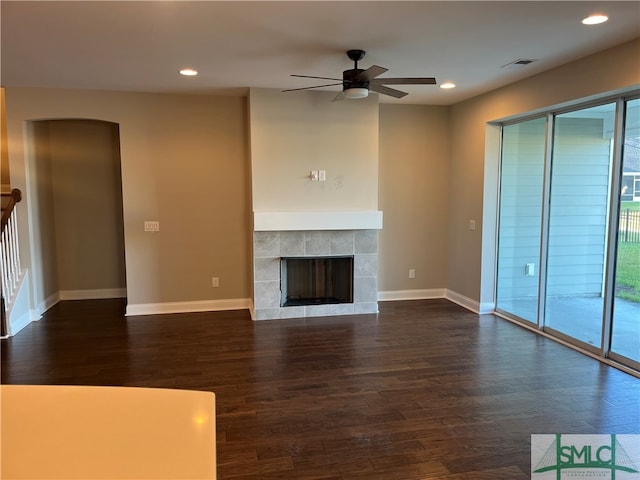 unfurnished living room featuring dark wood-type flooring, ceiling fan, and a tile fireplace