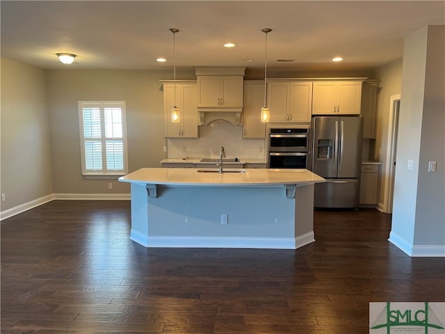 kitchen with dark wood-type flooring, a kitchen island with sink, hanging light fixtures, and stainless steel appliances