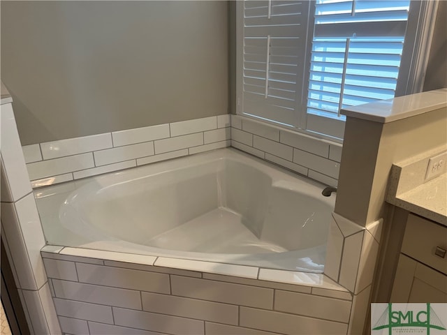 bathroom featuring vanity and a relaxing tiled tub