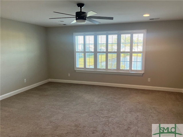 spare room with ceiling fan, carpet flooring, and plenty of natural light