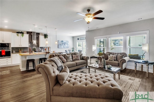 living room with dark hardwood / wood-style floors and ceiling fan