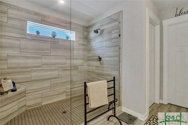 bathroom with hardwood / wood-style floors and tiled shower