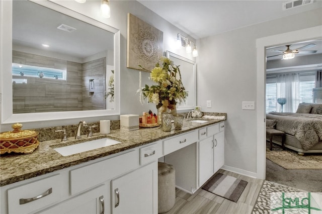 bathroom featuring vanity, hardwood / wood-style floors, a tile shower, and ceiling fan