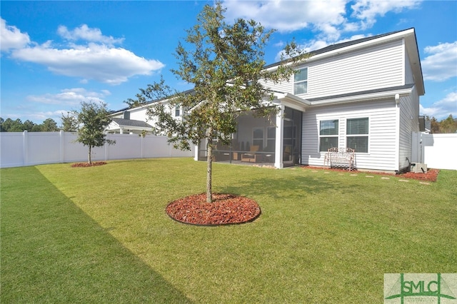 rear view of house with a sunroom and a lawn