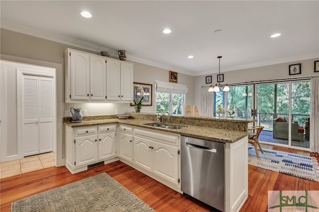 kitchen with sink, white cabinetry, light hardwood / wood-style floors, decorative light fixtures, and stainless steel dishwasher