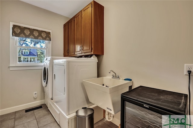 laundry area featuring sink, light tile patterned flooring, cabinets, and washing machine and clothes dryer