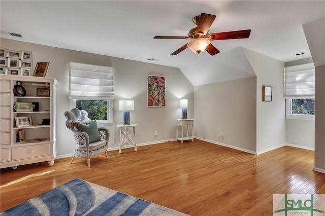 living area featuring a wealth of natural light, vaulted ceiling, light hardwood / wood-style floors, and ceiling fan