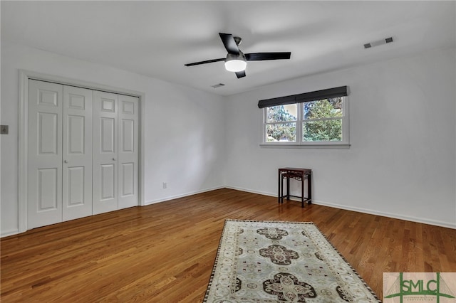 bedroom with wood-type flooring, a closet, and ceiling fan