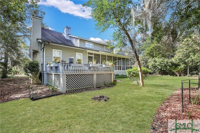 back of house with a wooden deck, a sunroom, and a yard