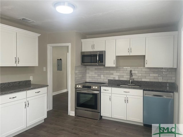 202 Forrest Ave, Savannah, GA 31404 - kitchen with appliances with stainless steel finishes, a sink, white cabinetry, backsplash, and dark wood finished floors