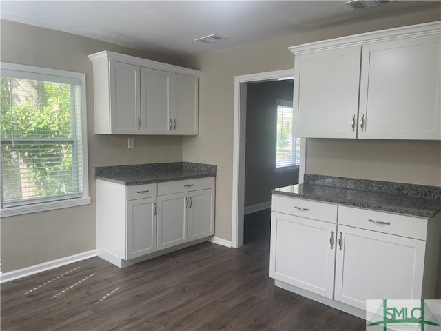 kitchen with dark wood-type flooring and white cabinets