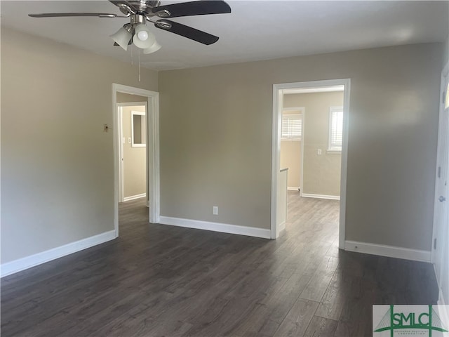 empty room featuring dark wood-type flooring and ceiling fan