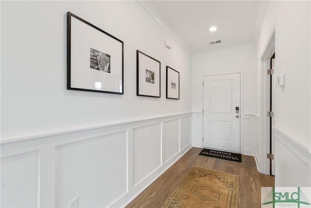 corridor with dark hardwood / wood-style floors and crown molding