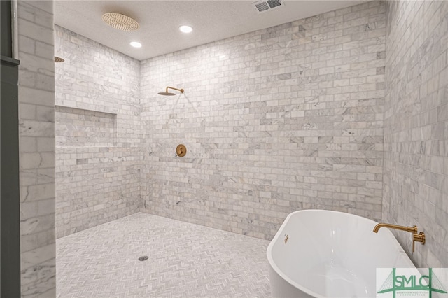 bathroom featuring plus walk in shower and a textured ceiling